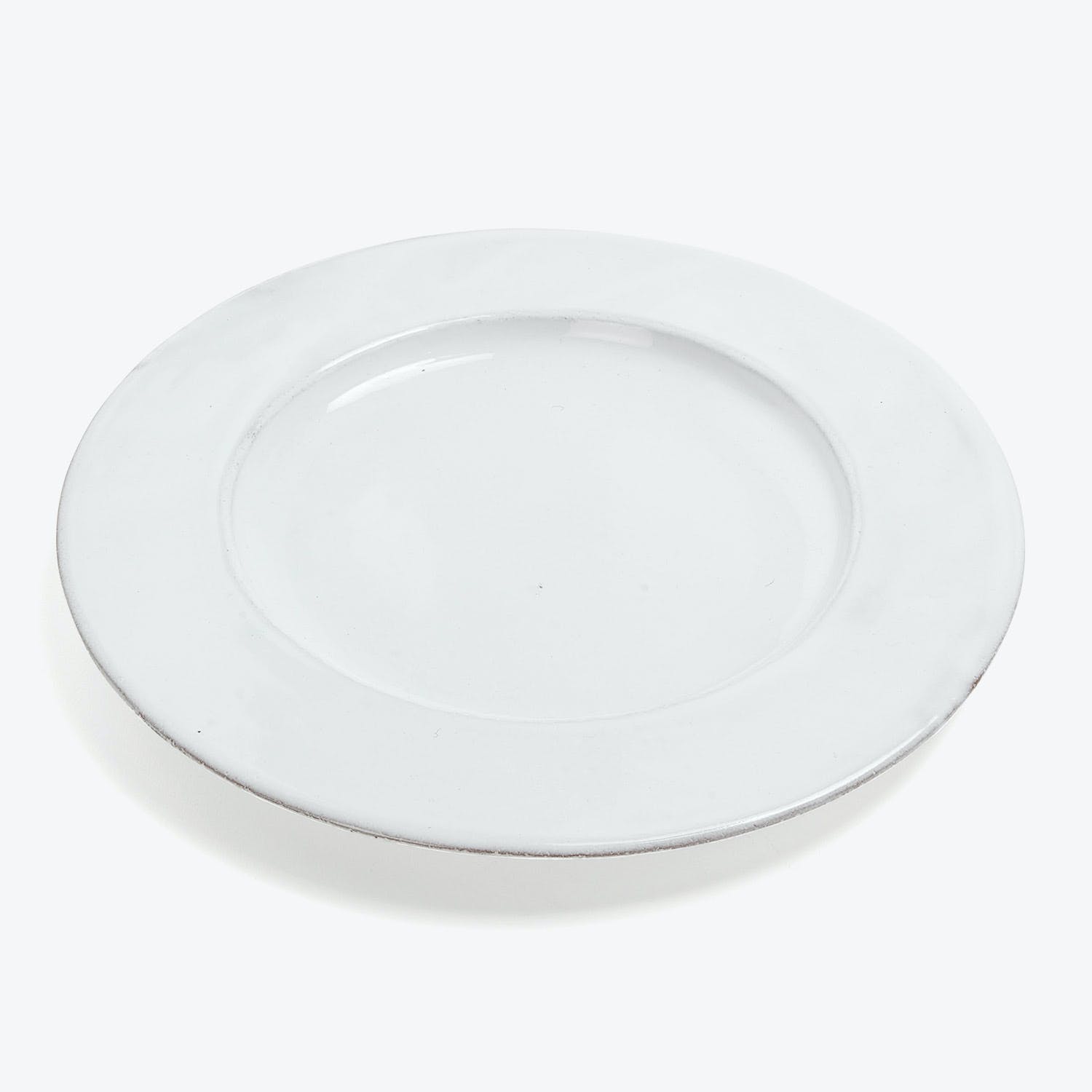 Minimalist white plate with a subtle raised edge and center depression.