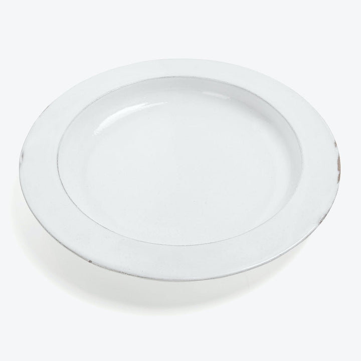 Plain white, circular plate with a chip on the edge.