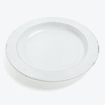 Plain white, circular plate with a chip on the edge.