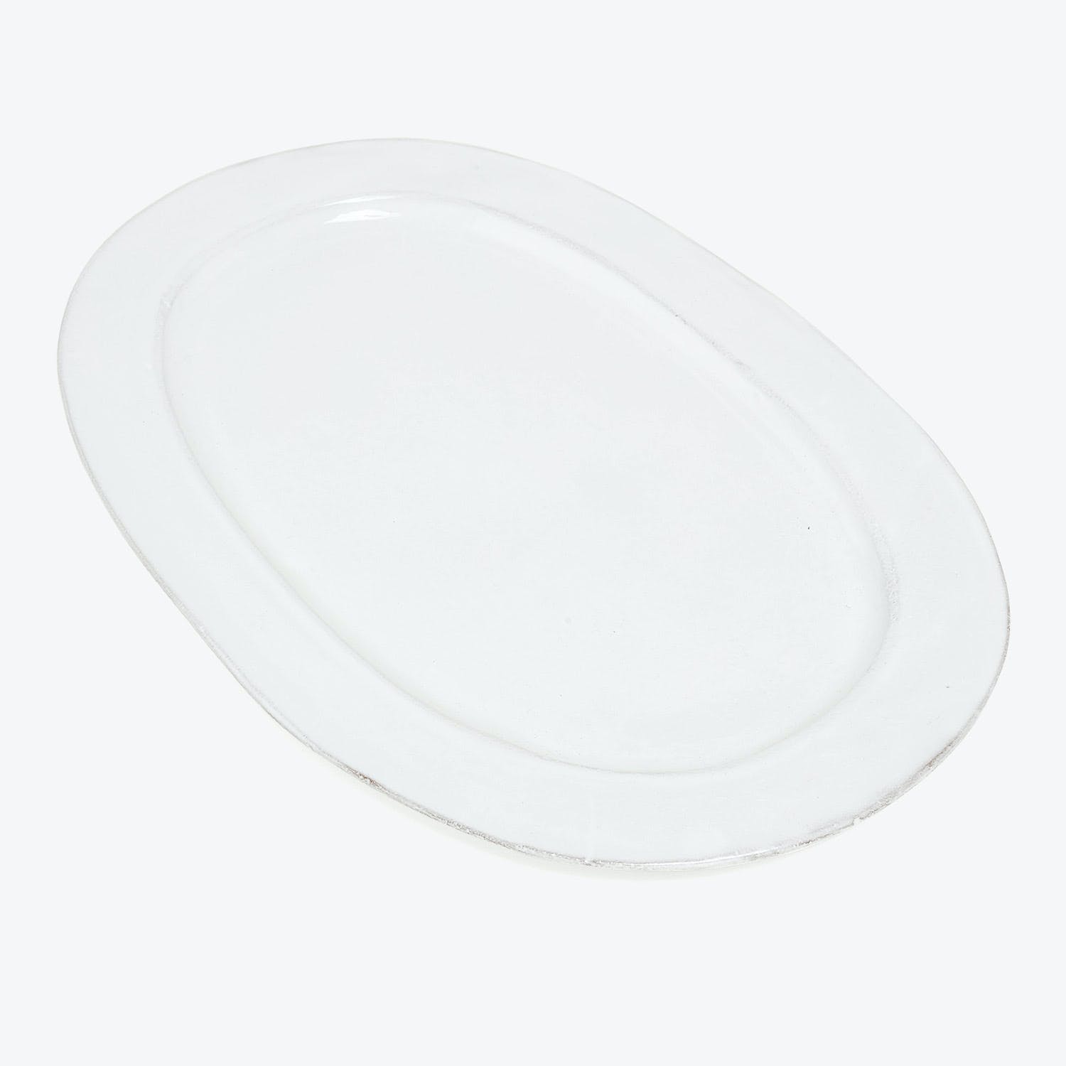 Minimalist white plate with a glossy finish reflecting light.