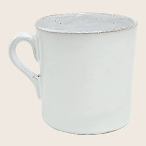 Vintage white enamel mug with distressed look and chipped edges.