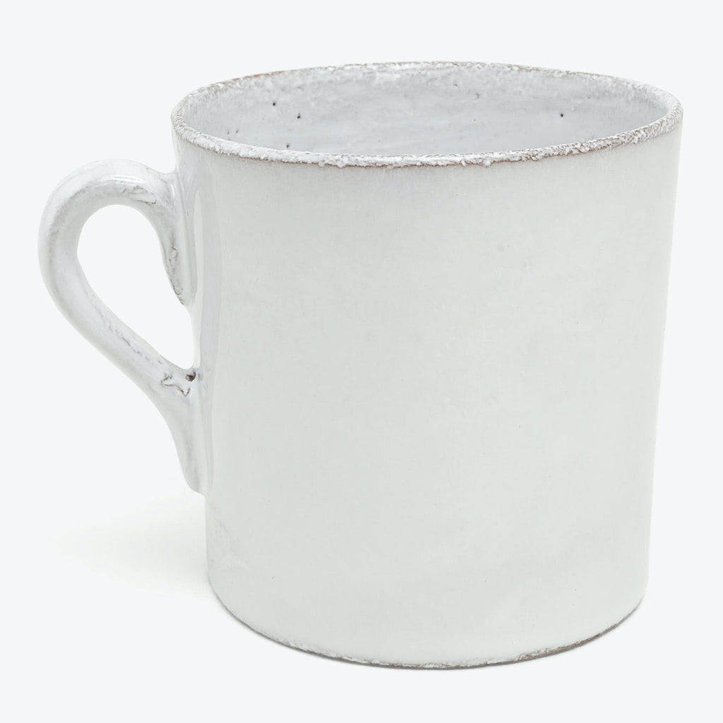 Vintage white enamel mug with distressed look and chipped edges.