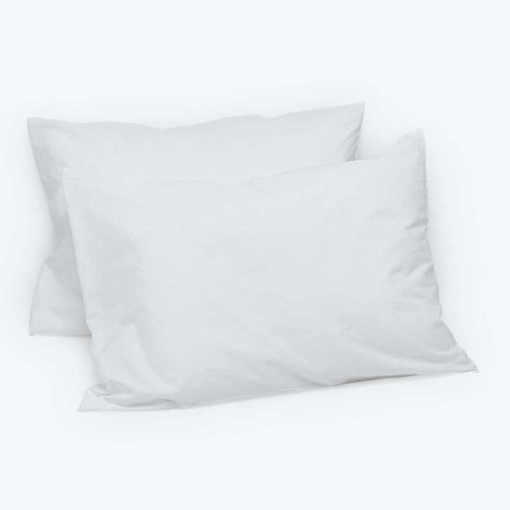 Two plain white pillows, overlapping, create a clean bedding look.