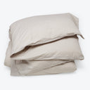 Soft and neutral beige bed linens with envelope closure pillowcases.