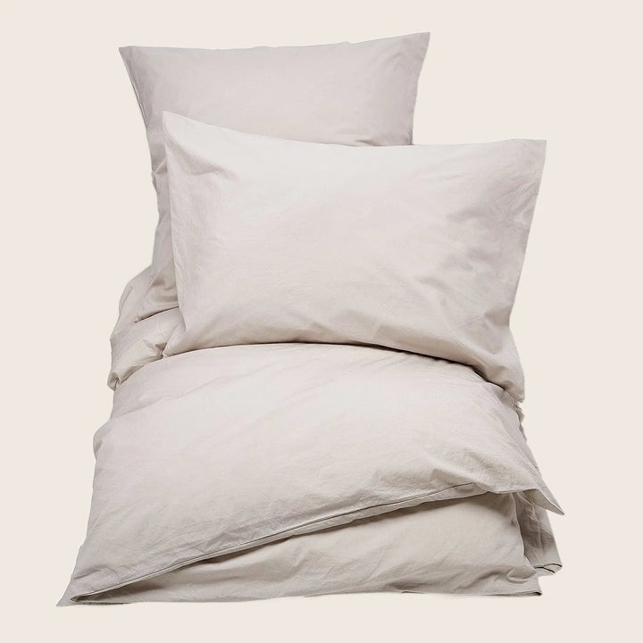 Neutral and cozy bedding set in soft, off-white tones.