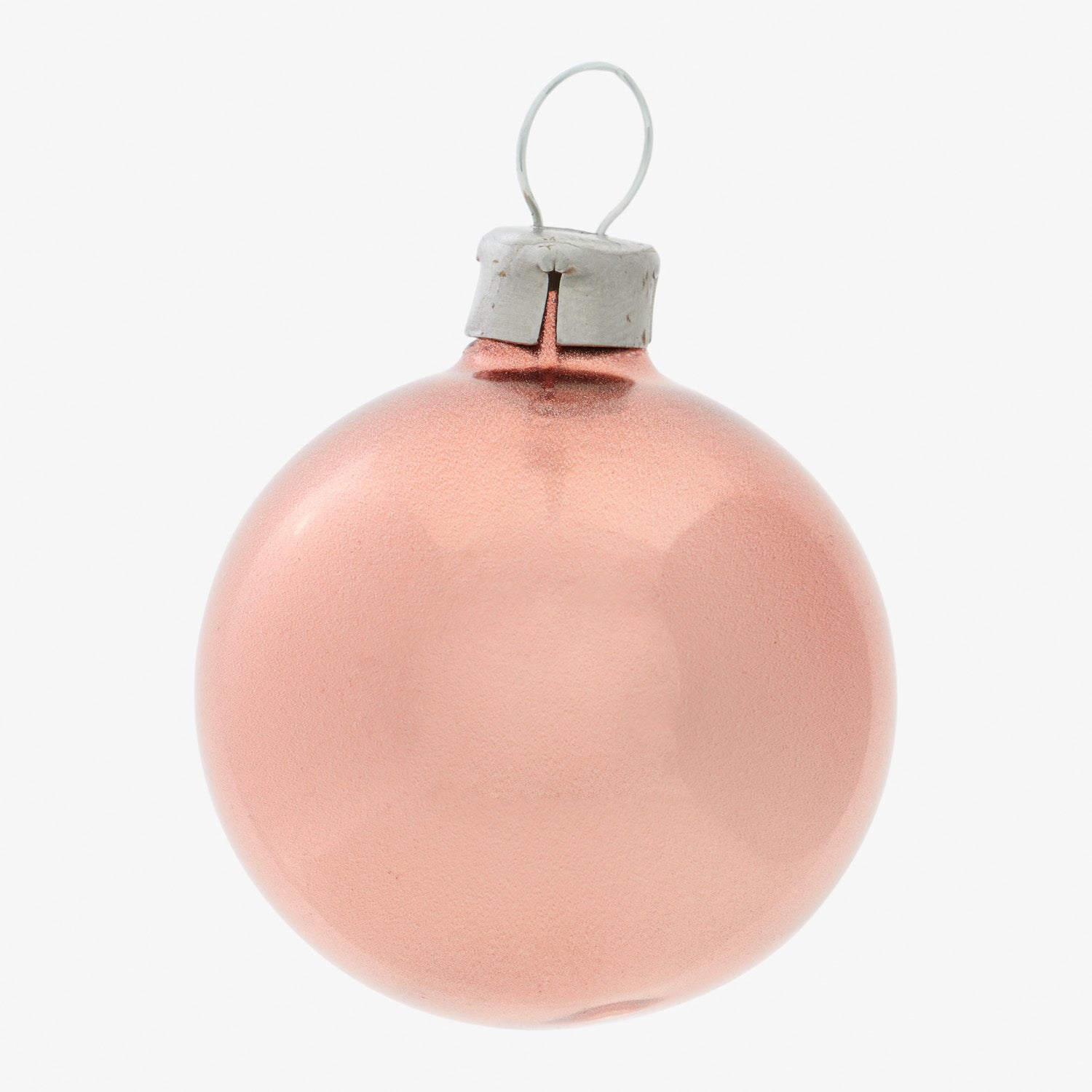 Simple, pink spherical Christmas ornament with silver cap on white background.