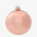 Matte peach Christmas ornament with silver cap and subtle reflections.