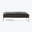 Modern-style ottoman with dark gray upholstery and sleek metal legs.