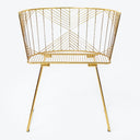 Modern wireframe chair in gold, blending industrial design and elegance.