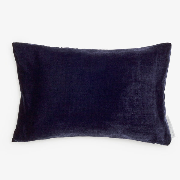 Rectangular velvet-like pillow in dark color with visible tag.