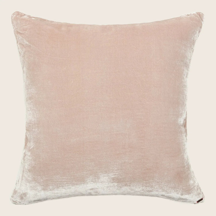 Pale pink velvet decorative pillow with subtle distressed texture.