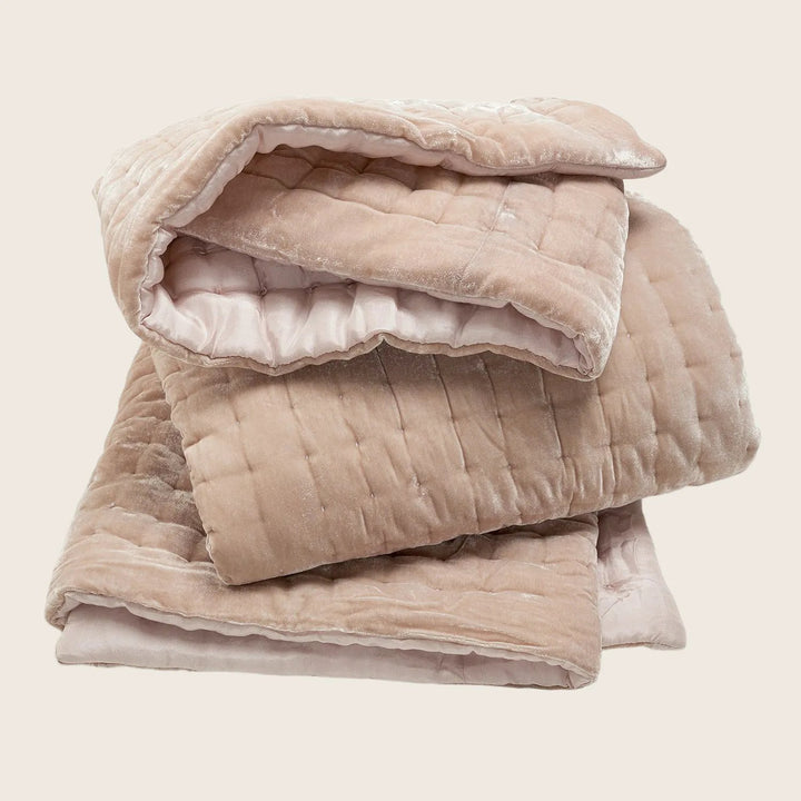 Stack of pink quilted comforters, perfect for warmth and comfort.