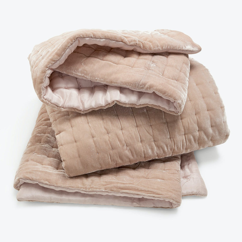 Stack of pink quilted comforters, perfect for warmth and comfort.