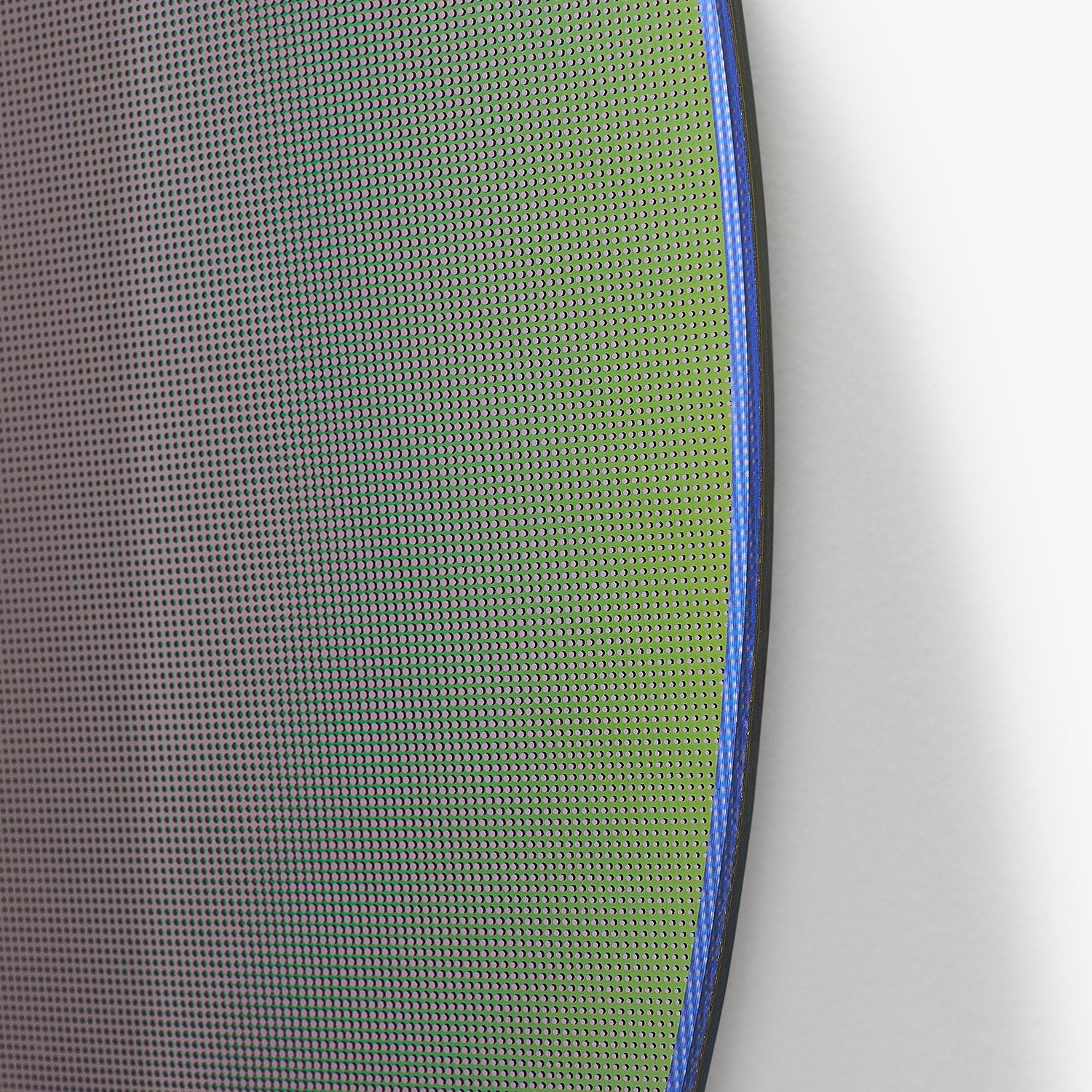 Close-up of green mesh material with blue piping edge detail.