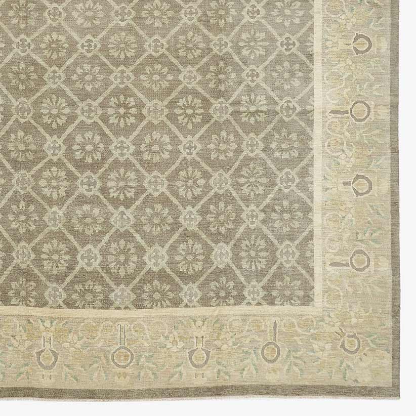 Close-up of an intricate and ornate rug with diamond lattice pattern and muted color palette