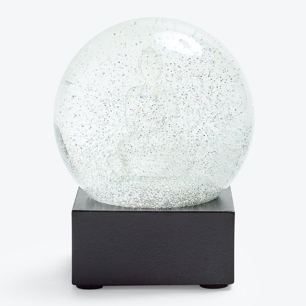 Modern and minimalist snow globe with shimmering glitter particles.