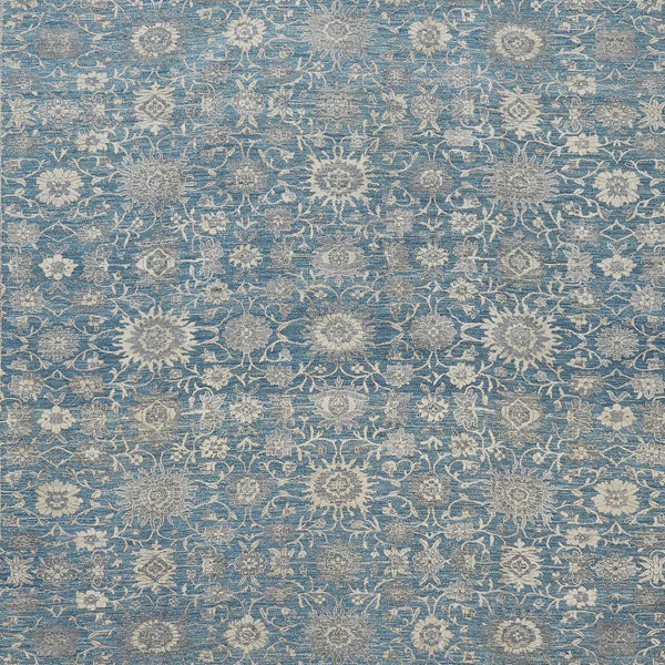 Close-up view of blue fabric with dense, ornate floral pattern.