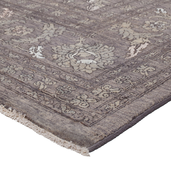 Close-up of a traditional patterned rug with muted tones and fringing.