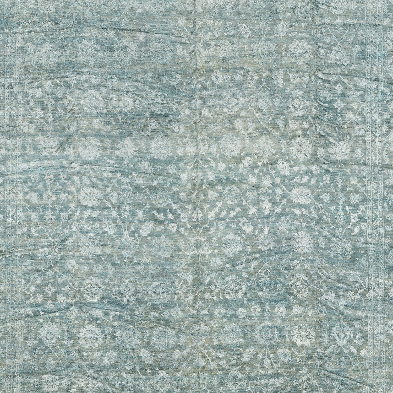 Close-up of a vintage-inspired blue rug with intricate floral motifs