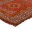Intricate, colorful handwoven rug with geometric and floral motifs.