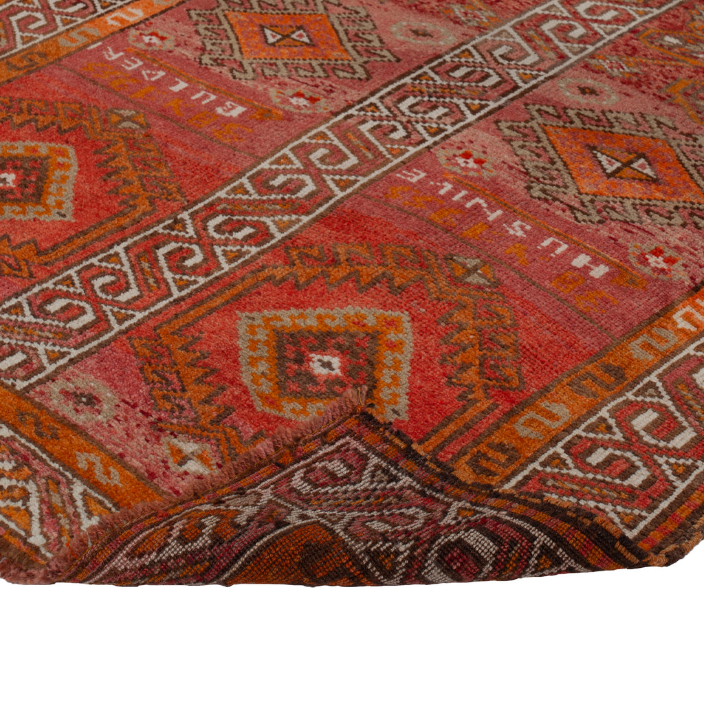 Intricately designed rug with vibrant geometric patterns in warm colors.