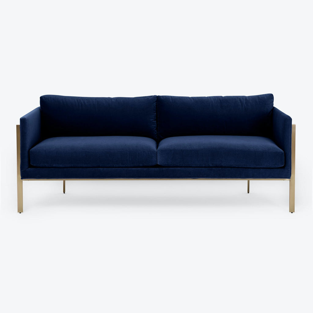 Modern minimalist sofa with deep blue velvet upholstery exudes sophistication.