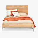 Modern wooden bed with stylish bedding and minimalist design.