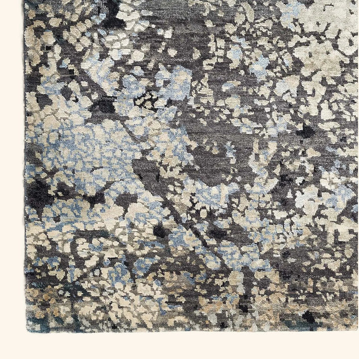 Close-up view of a modern, mottled patterned rug on hardwood.
