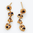 Luxurious gold-tone dangle earrings with intricate detailing and blue gemstones.
