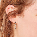 Elegant gold earring adorned with alternating diamond and sapphire gemstones.