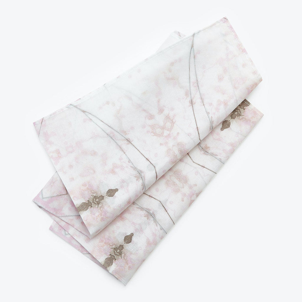 Exquisite folded textile with marbled pattern in delicate pink and gold.