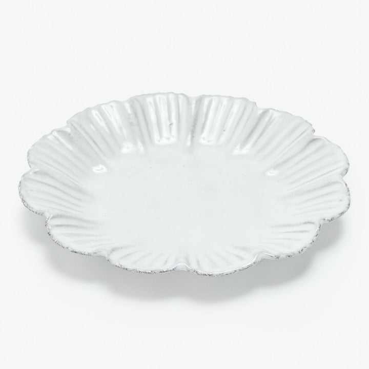 White scalloped-edge plate with seashell-inspired design photographed on white background.