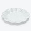 White scalloped-edge plate with seashell-inspired design photographed on white background.