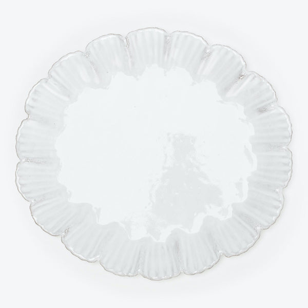 Elegant white plate with textured surface and ruffled rim design.