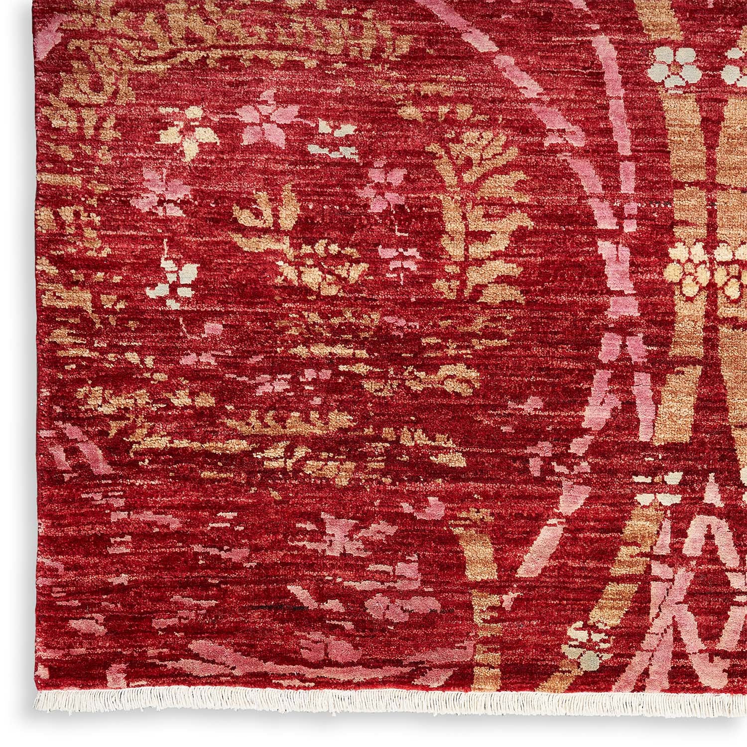 Intricately patterned, rich red textile with botanical motifs and worn texture.