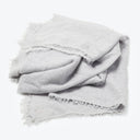 Frayed gray textile with textured appearance, laid against white background.