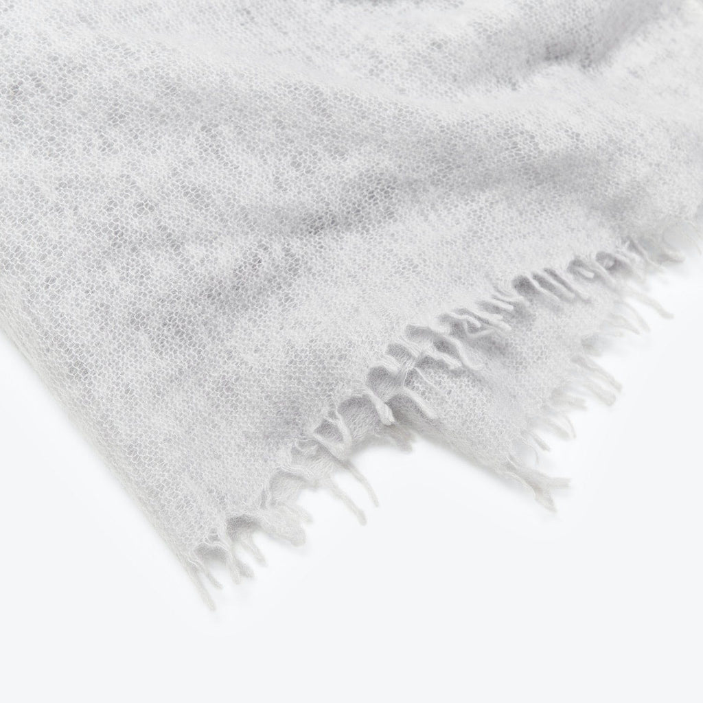 Close-up view of a soft, gray fabric with fringe detail.