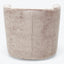 Plush, cylinder-shaped ottoman in light neutral tone with textured upholstery.