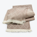 Neatly folded chevron pattern throw blanket with fringe detailing