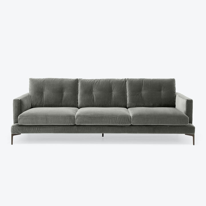 Minimalist modern sofa with plush velvet upholstery in dark tones.