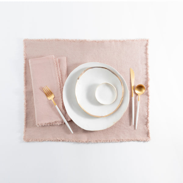 Elegant gold-themed table setting with neatly stacked plates and cutlery