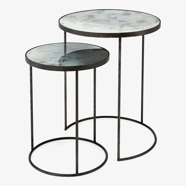 Minimalistic circular-top side tables with textured metallic finish and rings for stability.