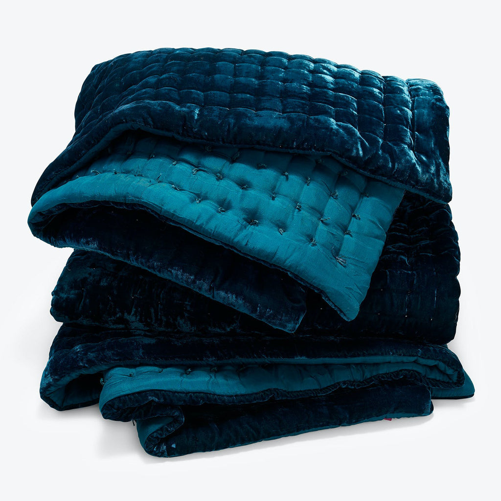 Folded, luxurious blue weighted blanket with quilted texture and sheen.