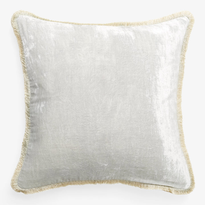 Square pillow with silvery-white cover and gold fringe border.