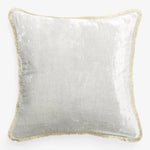 Square pillow with silvery-white cover and gold fringe border.