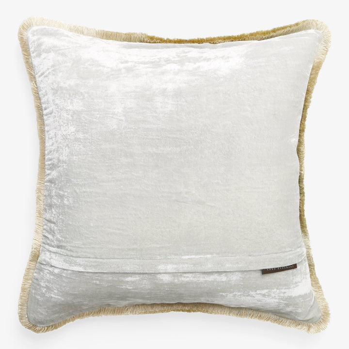 Luxurious velvet throw pillow with gold fringe and brand label.