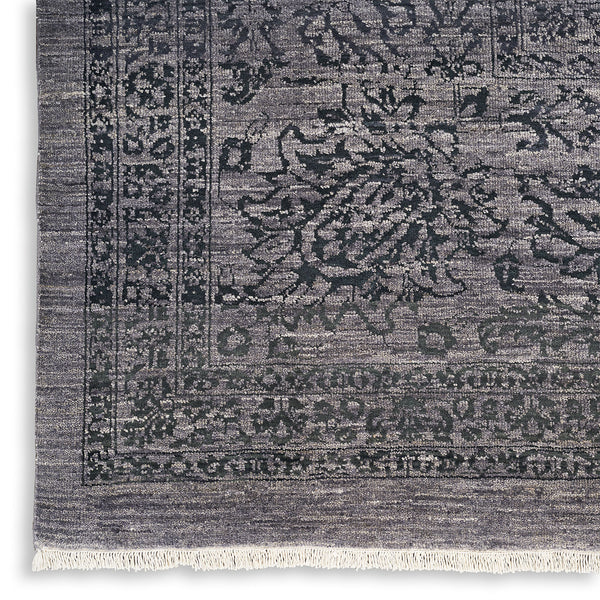 Vintage-inspired handwoven rug with symmetrical ornamental floral motifs on dark background.