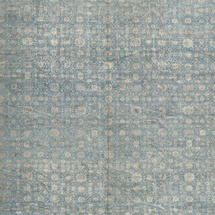 Vintage-inspired blue ornate pattern with distressed appearance on textured surface.