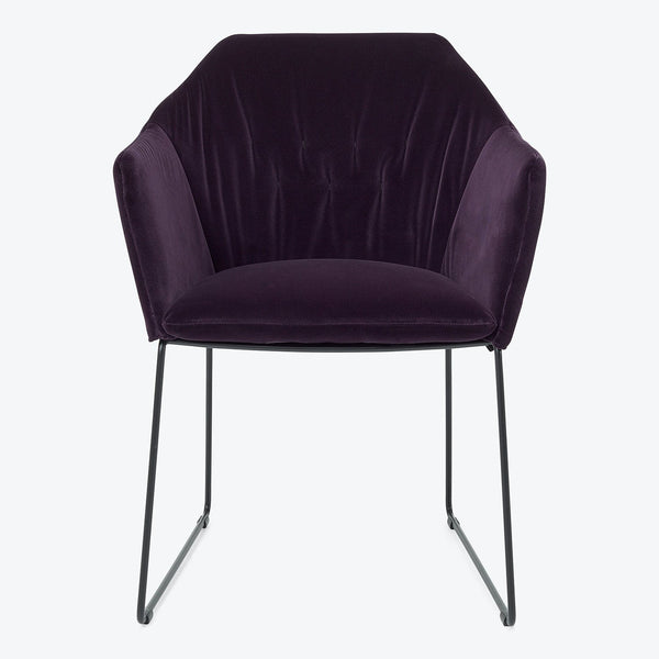 Modern chair with deep purple velvet upholstery exudes luxury.