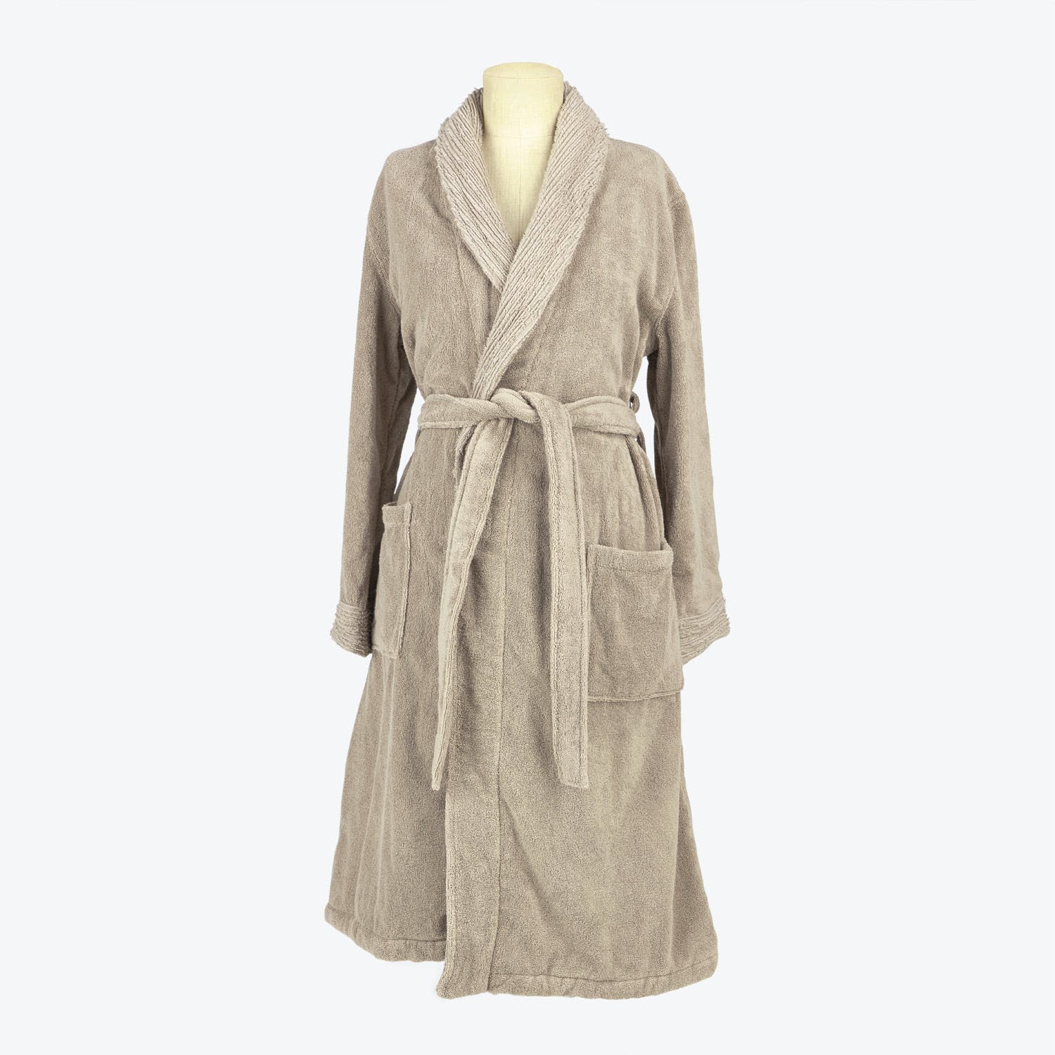 Beige terry cloth bathrobe with shawl collar and patch pockets.